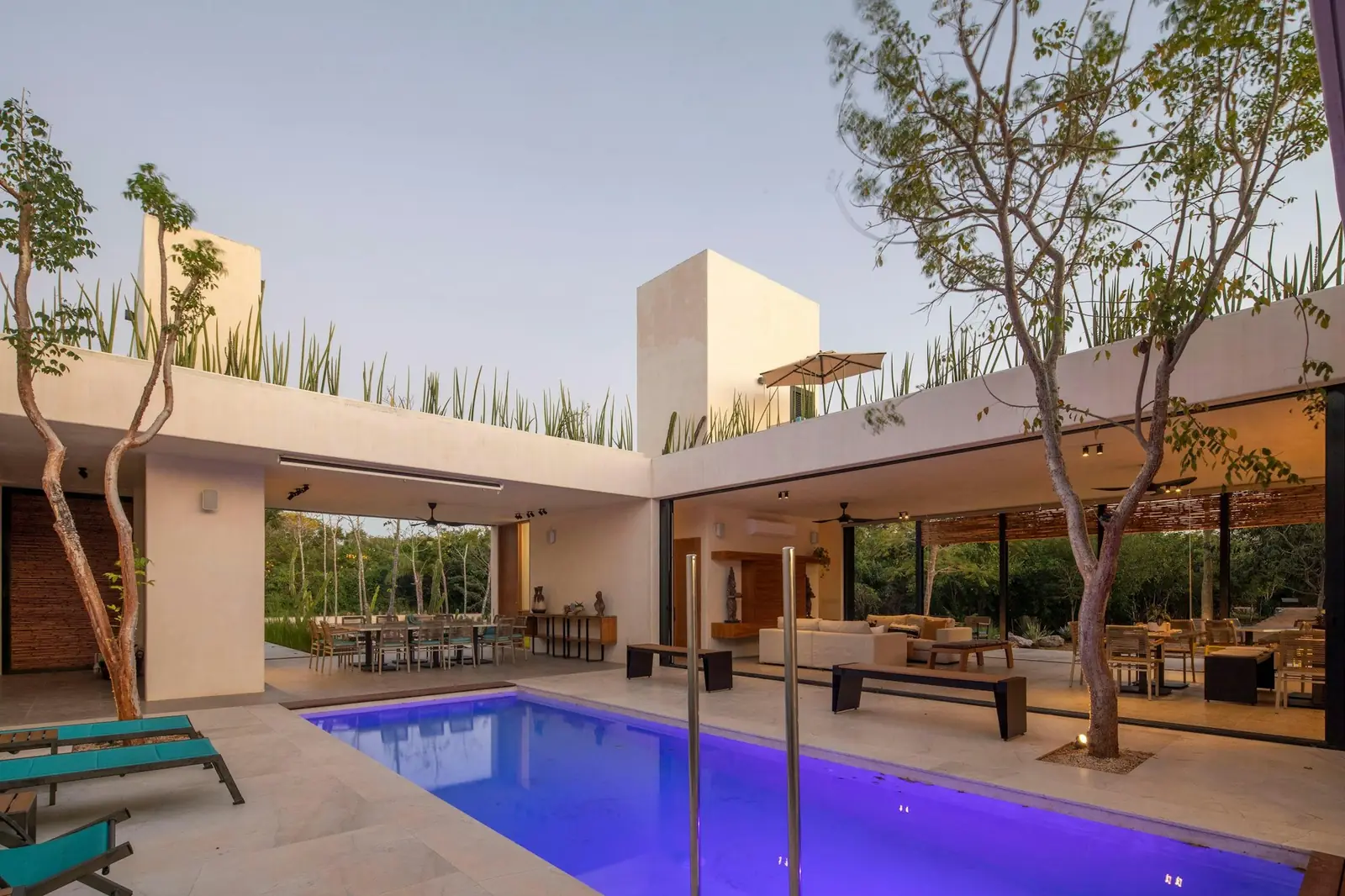 Casa moderna con alberca al atardecer